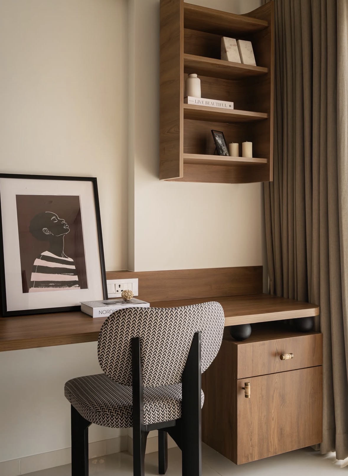 Built-in timber desk with open shelves, a framed print and a patterned chair