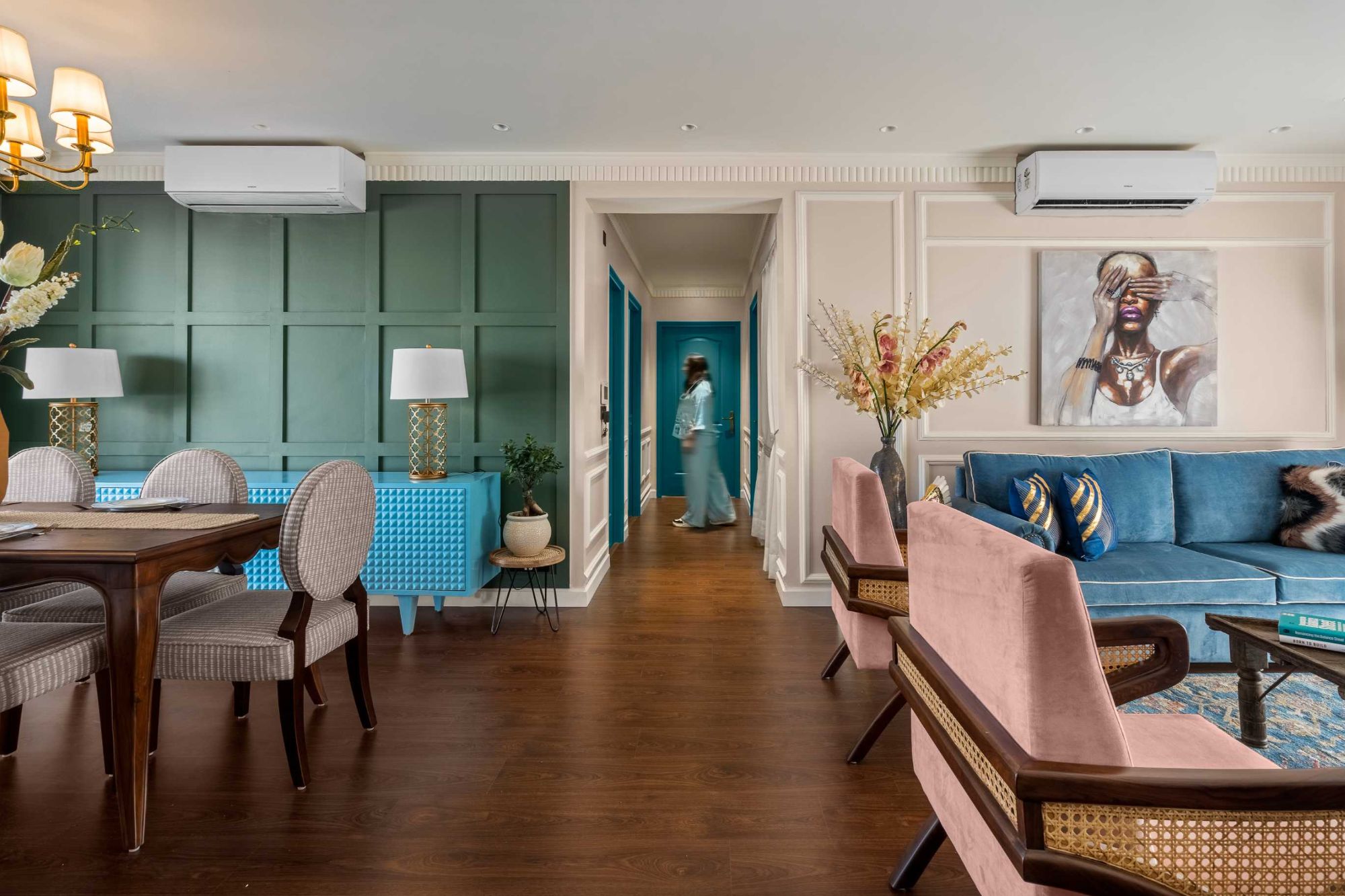 Hallway of teal doors seen between the dining table and the living room