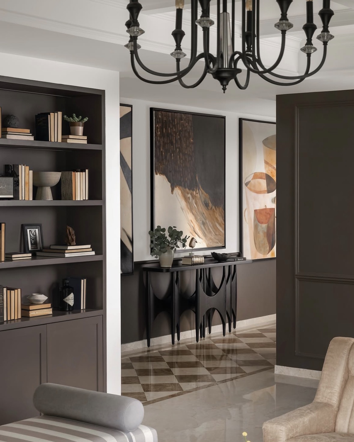 Sculptural black console beneath a large abstract painting, against dark panelling and a chequered marble floor