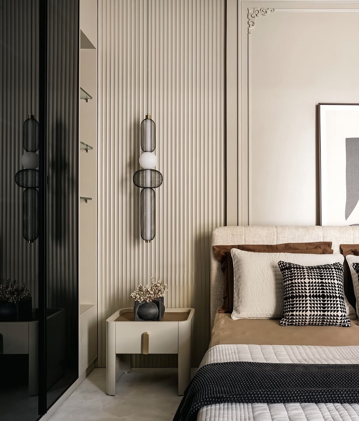 Bed with a cream headboard, a fluted wall panel, a cream bedside table and a mesh pendant light