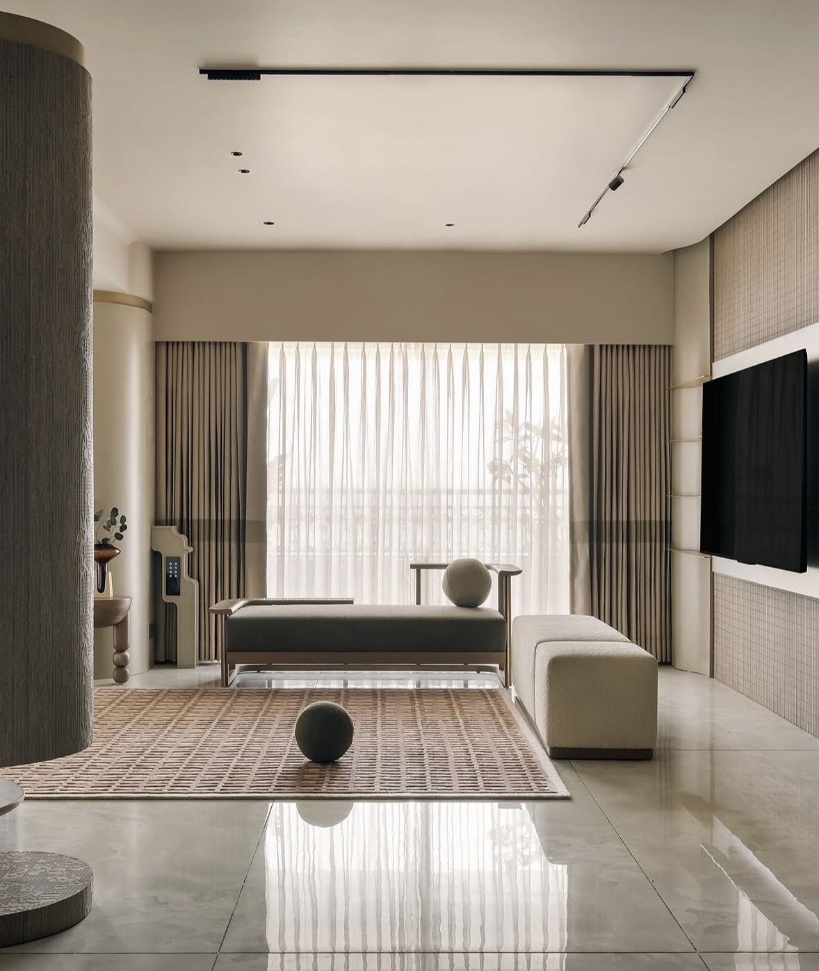 Living room with a daybed and bouclé ottoman facing sheer curtains, a wall-mounted television and a woven rug
