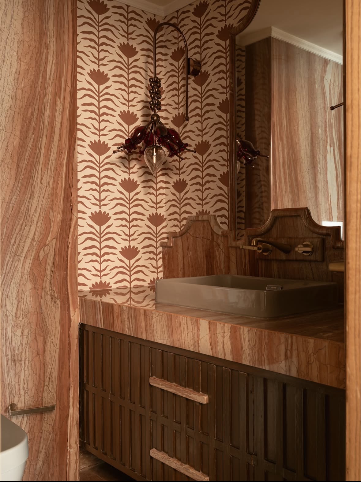 Powder room with a red-veined stone vanity, a patterned wallpaper and a stone basin