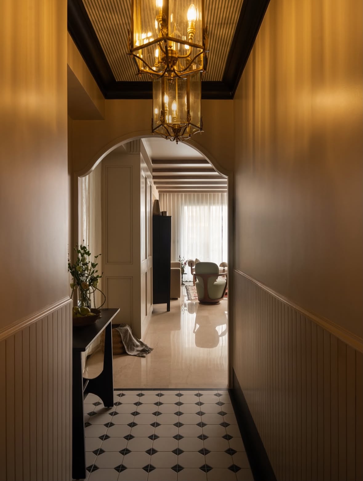 Corridor with a brass lantern, an arched doorway and a patterned floor