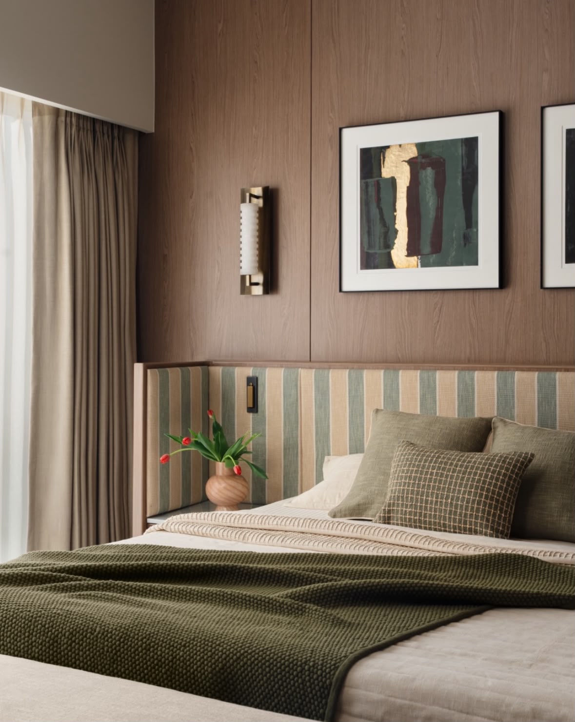 Bedroom with an olive throw, a striped headboard and a framed artwork