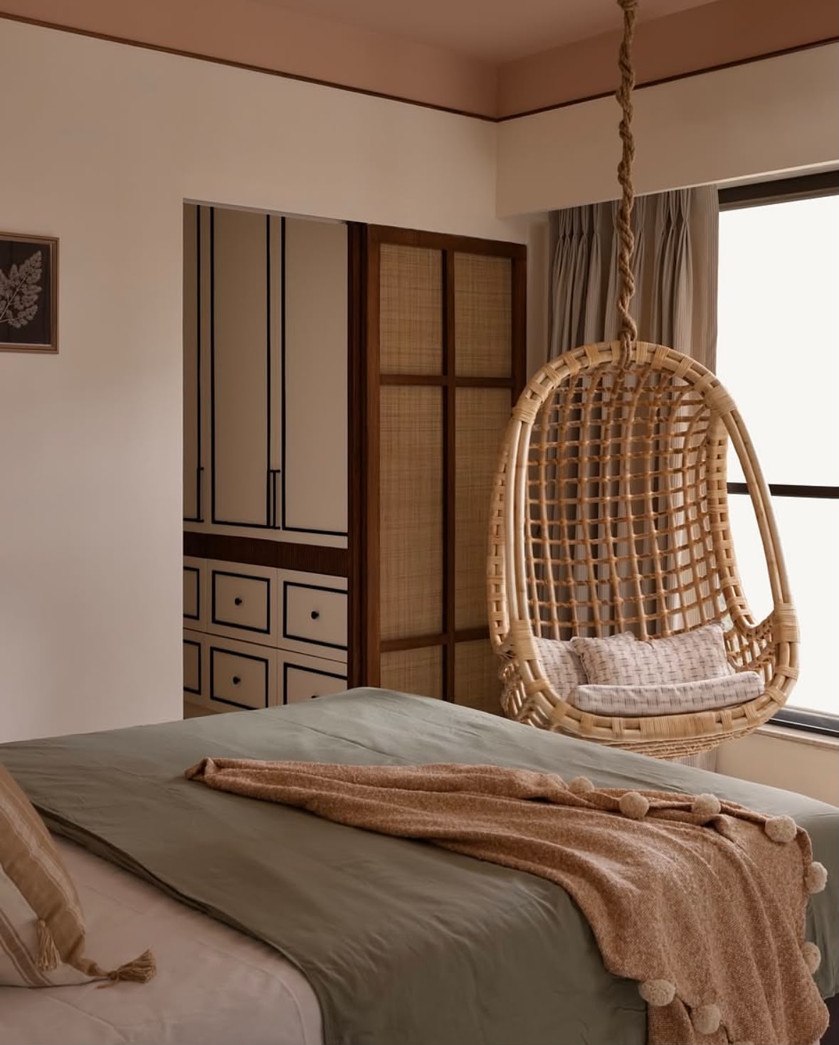 Bedroom with a hanging cane chair and cane-fronted wardrobes