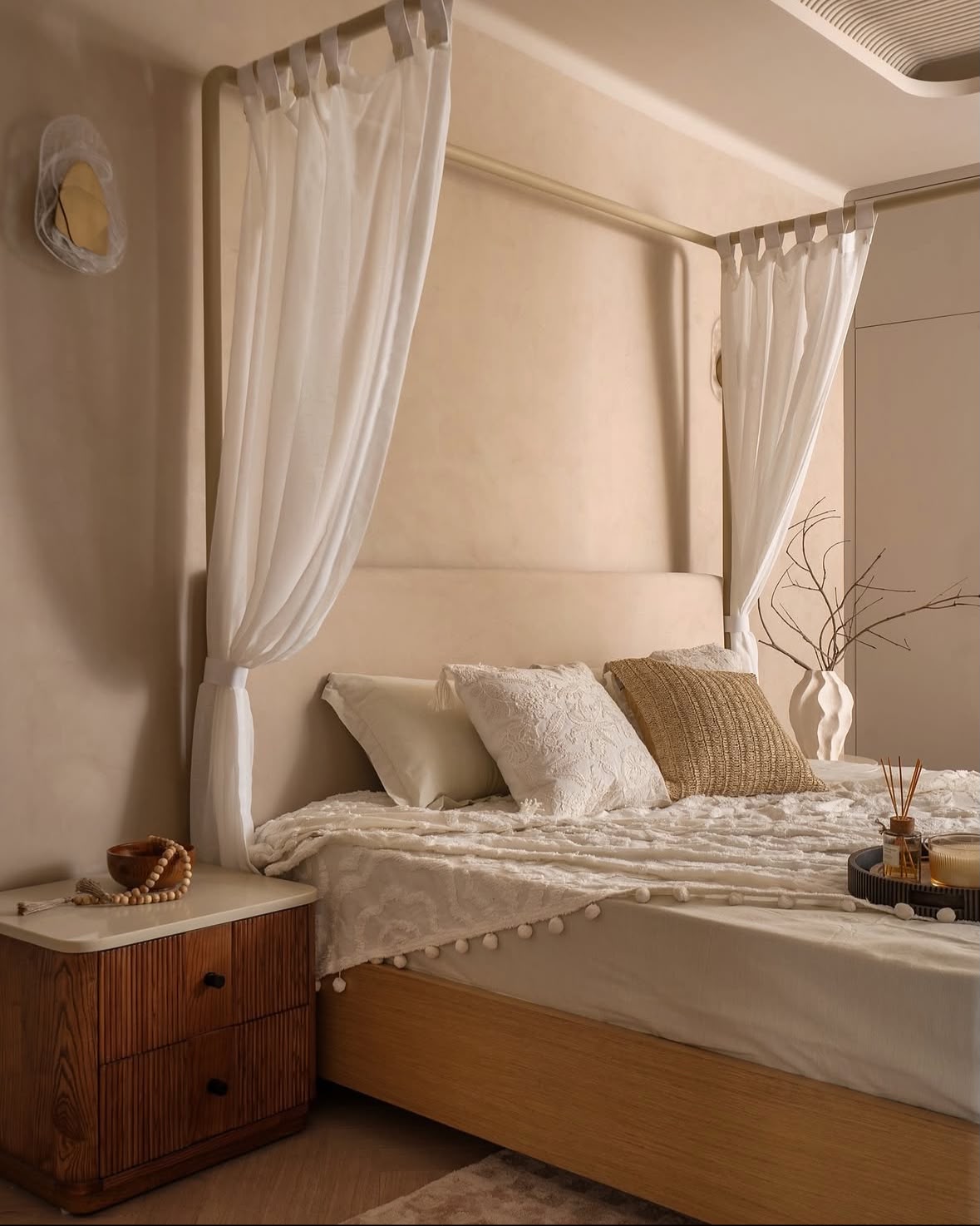 Bedroom with a four-poster bed in white drapes and a walnut bedside table