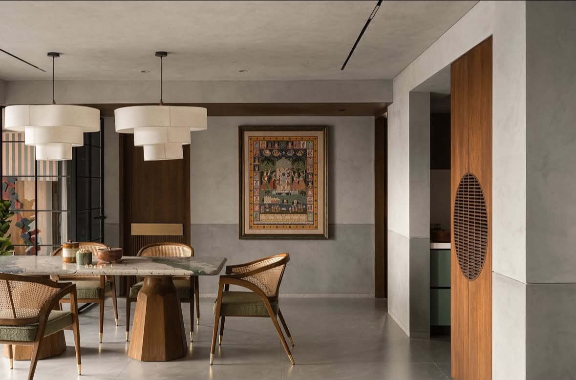 Dining area with a stone-topped table, cane chairs and a framed traditional painting