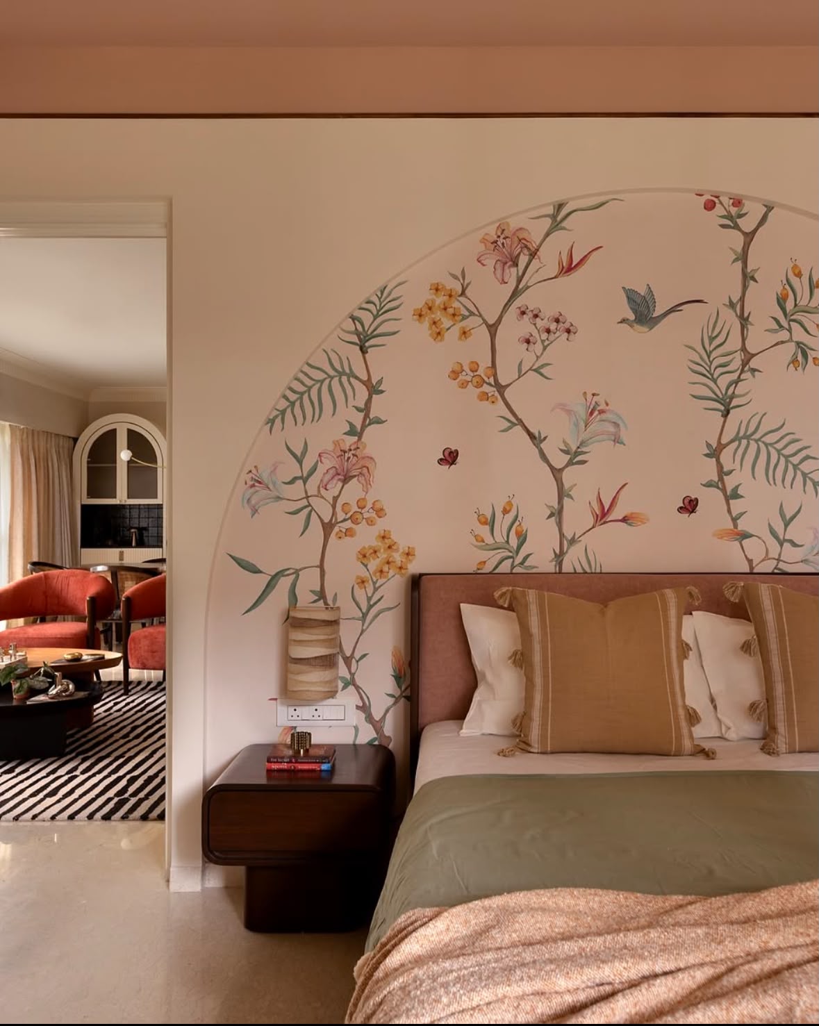 Hand-painted floral arch above a bed, with a living room seen through the doorway